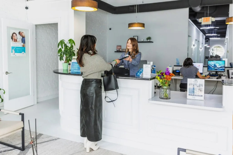 A patient being welcomed at the Embark Dental front desk
